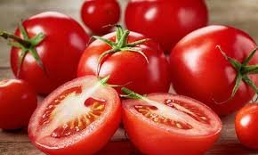 tomates-3 vários tomates maduros inteiros e um cortado ao meio.